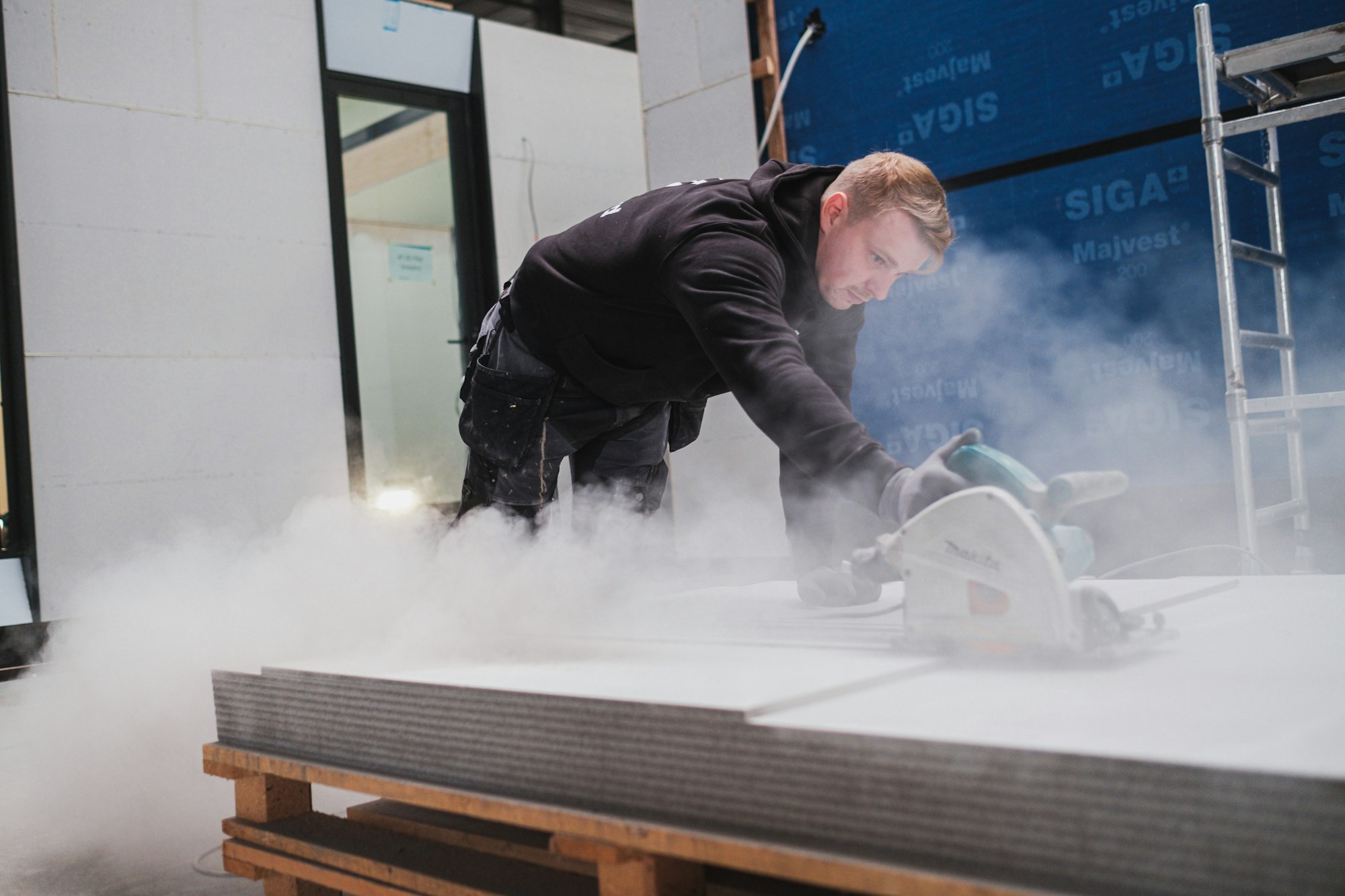 Bouwvakker werkt aan een prefab houtskeletbouw woning