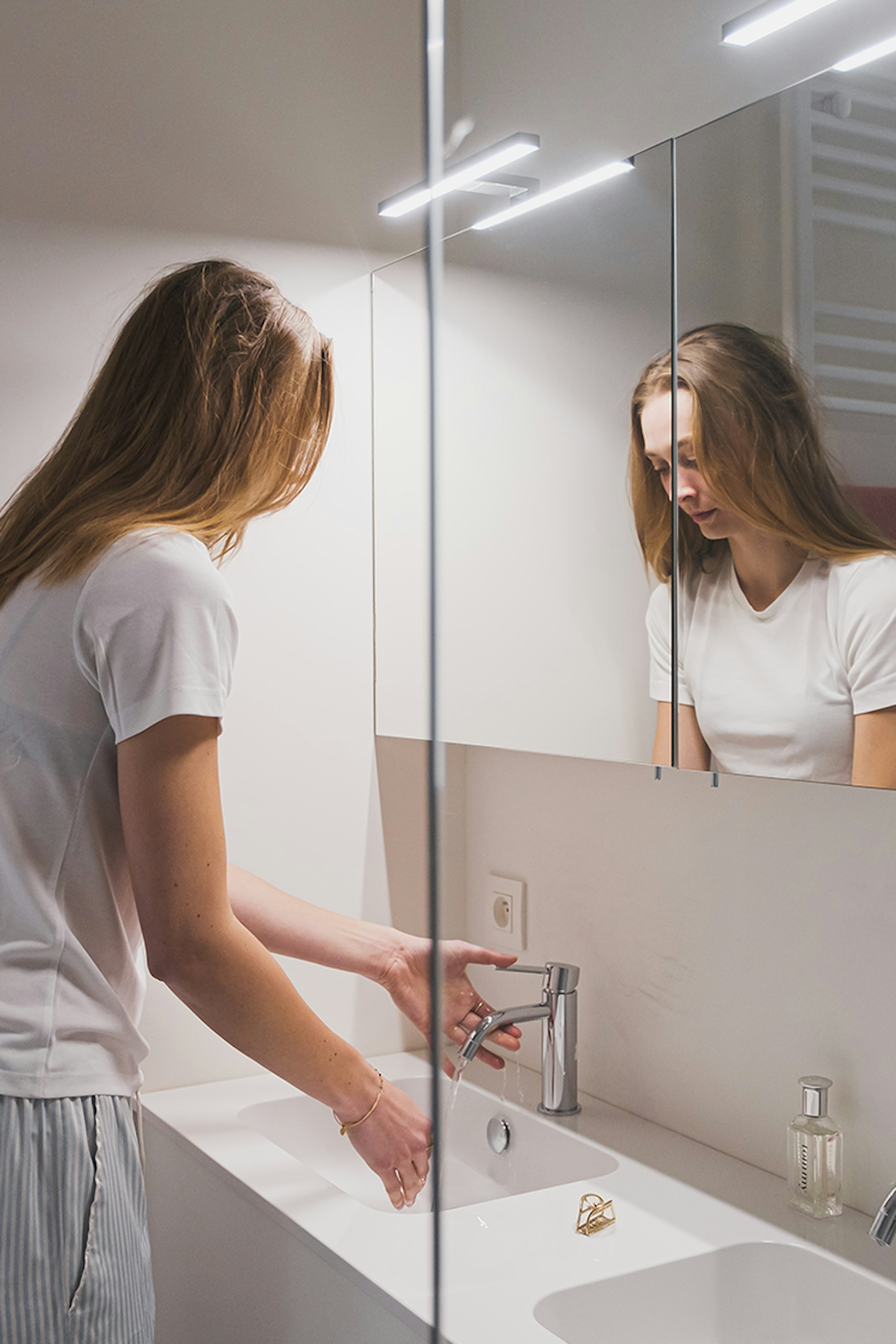 Jonge vrouw aan dubbele wastafel in een Skilpod badkamer