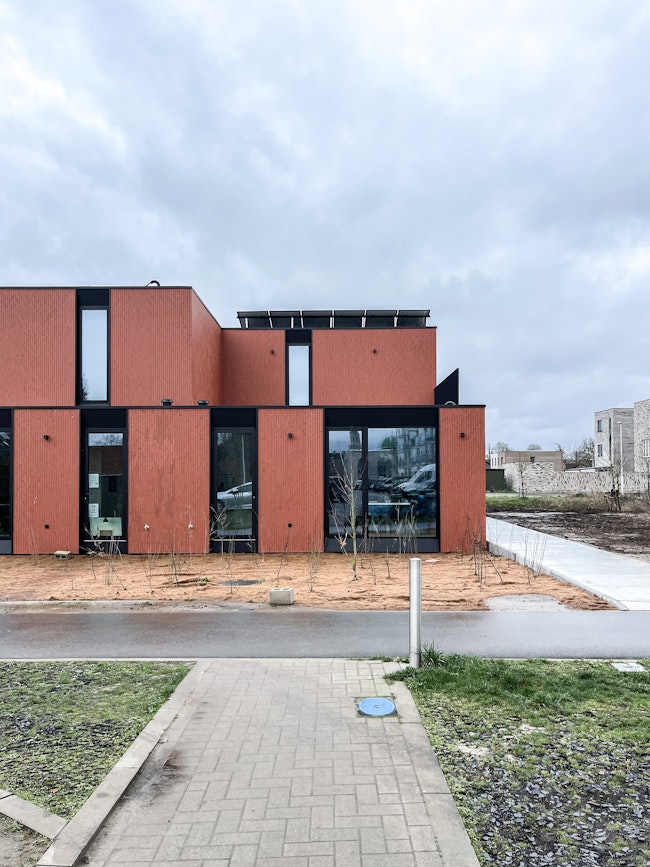 Halfopen-bebouwing Skilpod #130 afgewerkt in rode steen, met zonnepanelen