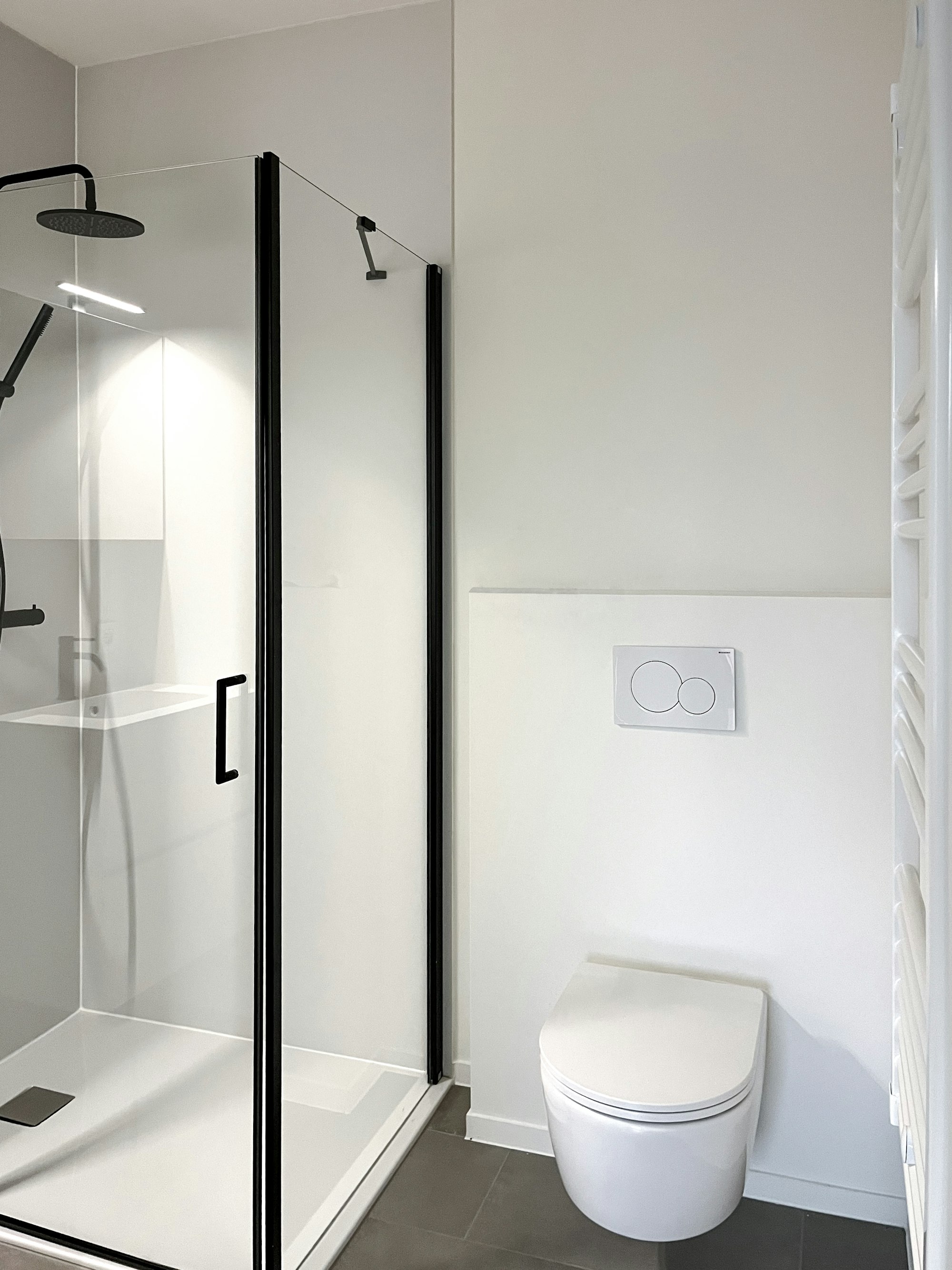 Badkamer bovenverdieping in de Skilpod #130 prefab houtskeletbouw woning, toilet en douche met matzwarte accenten