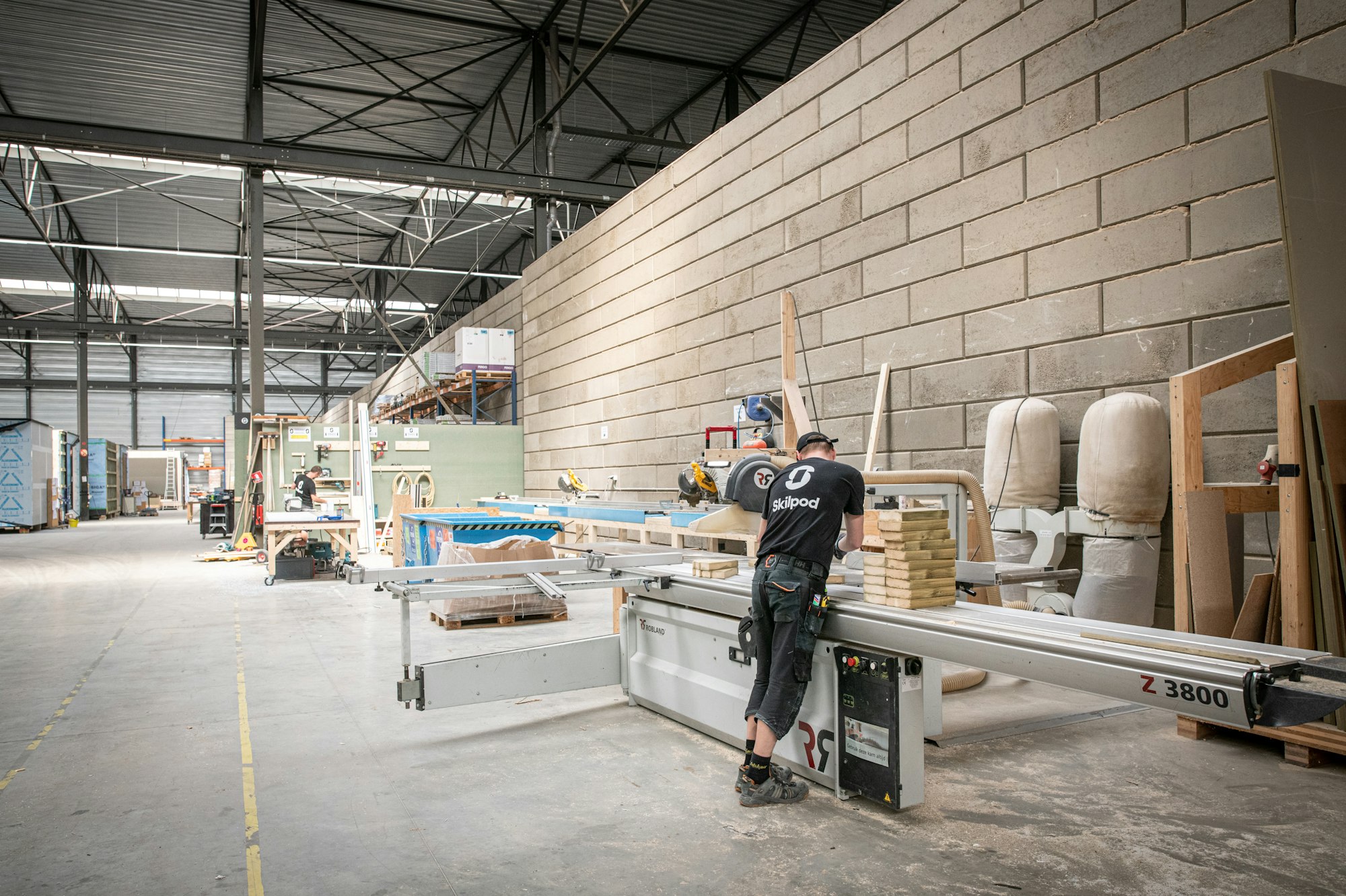 Vakmannen aan het werk in het modulaire houtbouw atelier van Skilpod in Geel