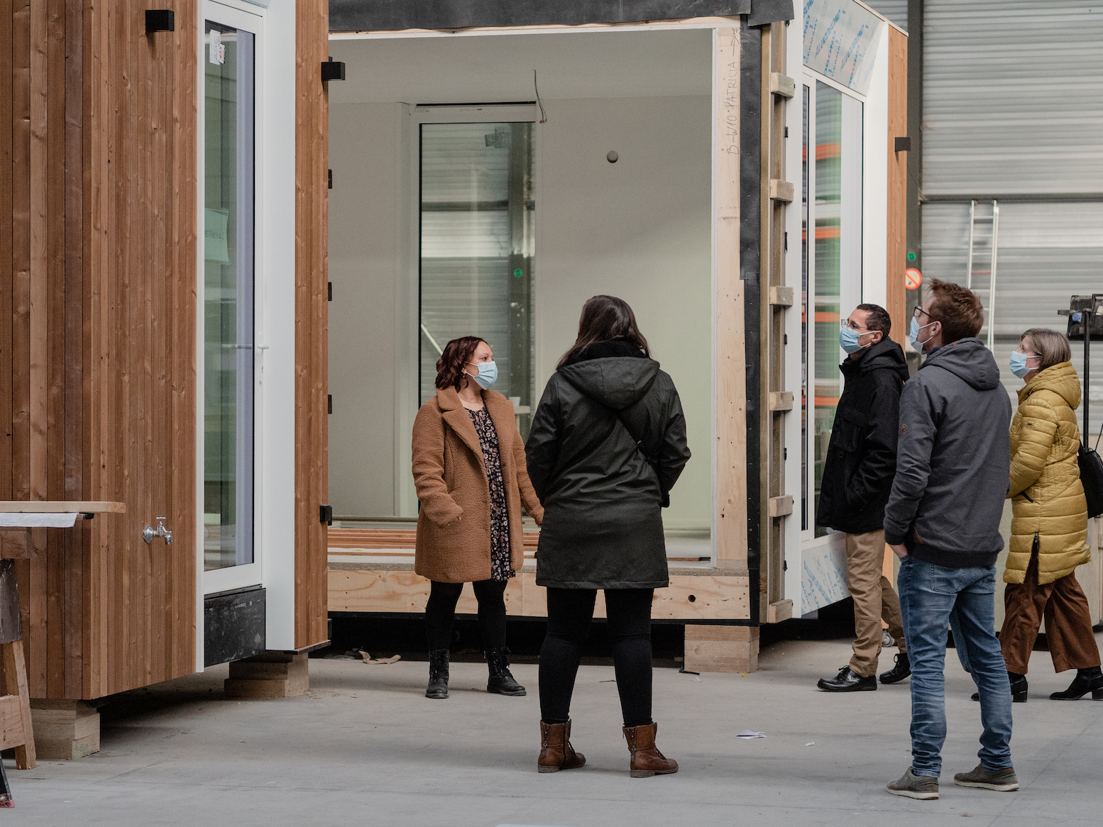 Mensen bezoeken de Skilpods in opbouw tijdens een open atelier