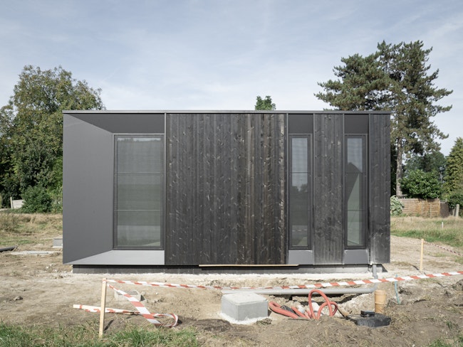 Houtskeletbouw woning Skilpod #100 in zwart hout, recent geplaatst op de bouwwerf