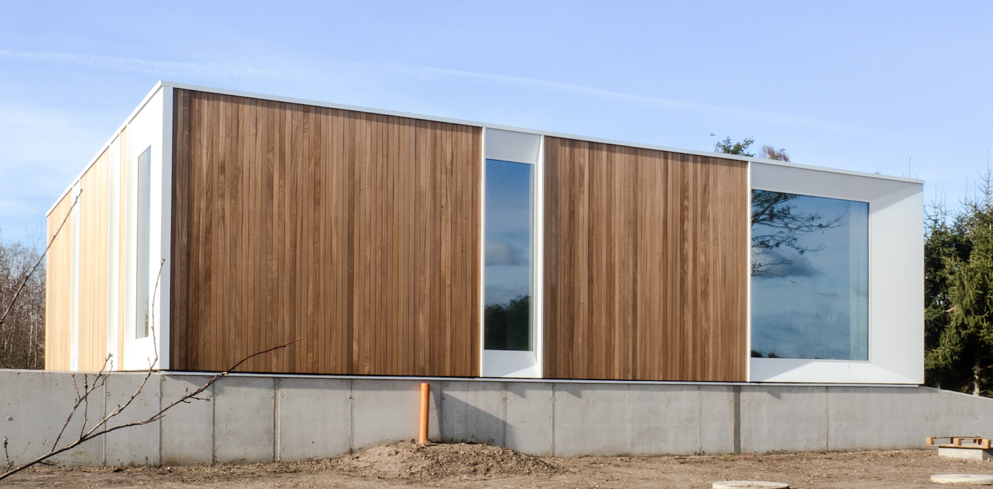 Houtskeletbouw modulewoning Skilpod #144, met houten exterieur en witte ramen
