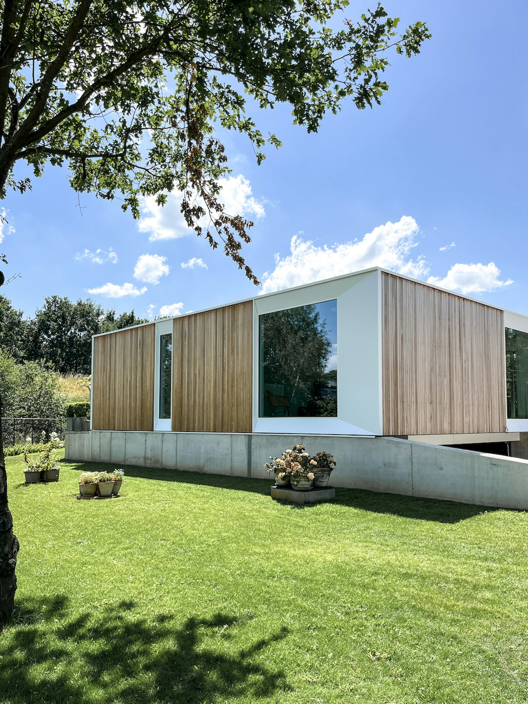 Prefab houtskeletbouw woning #144 van Skilpod. Afwerking in natuurhout en witte ramen.