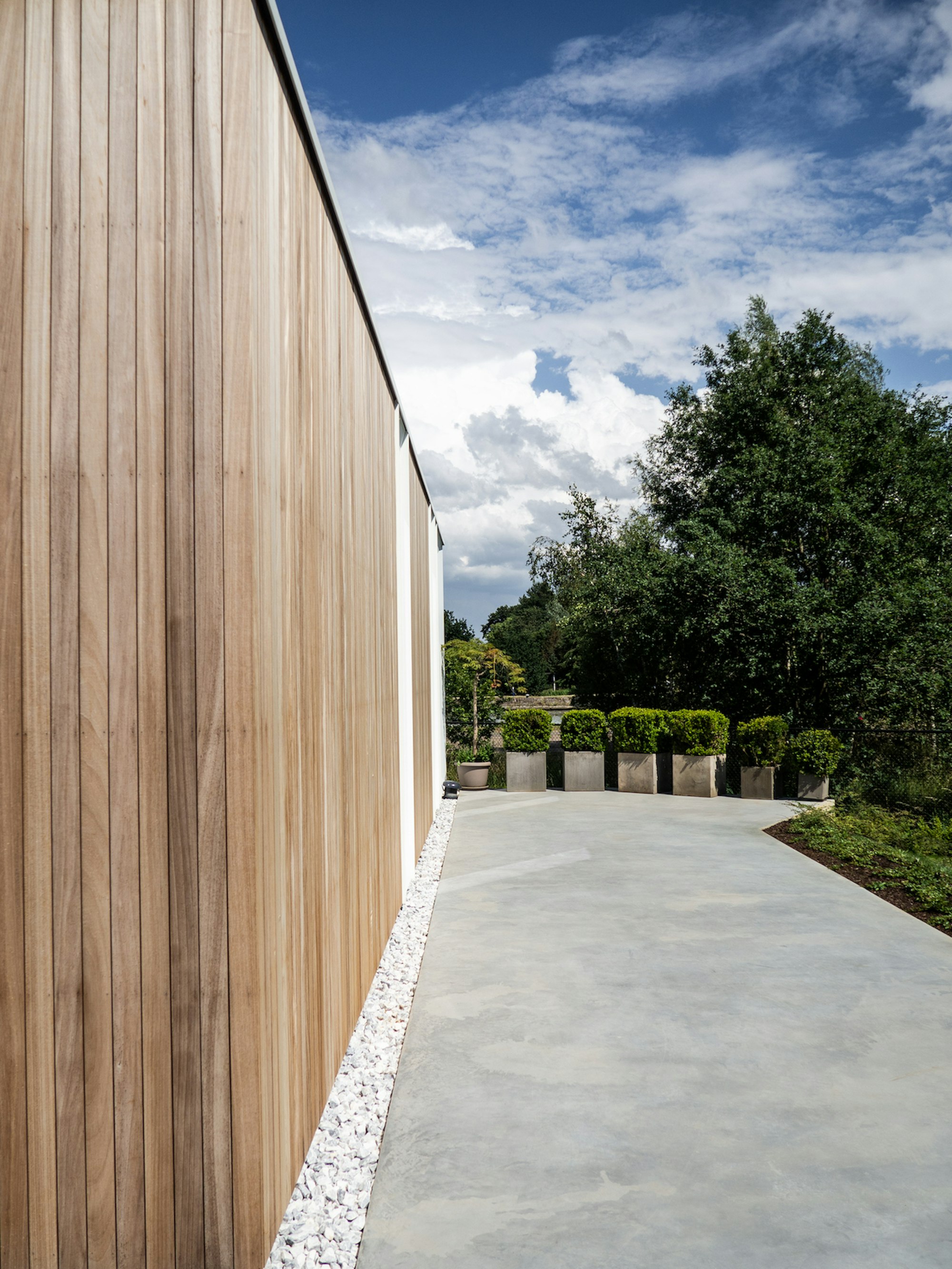 Detail zijmuur prefab houtskeletbouw woning #144 van Skilpod. Afwerking in natuurhout en witte ramen.