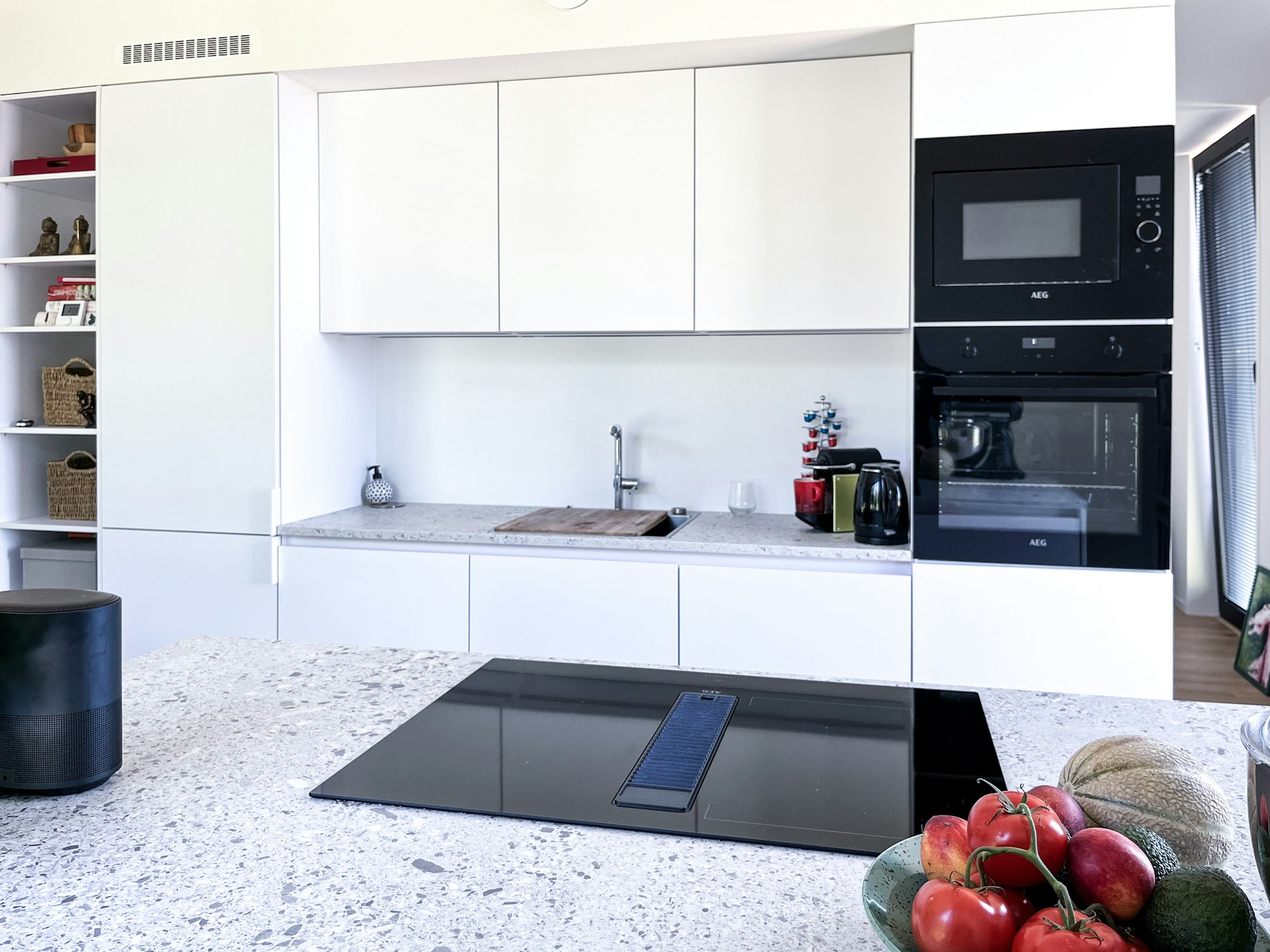 Keuken in een prefab woning Skilpod #80 met terrazzo stijl werkblad en inductie kookplaat met ingebouwde dampkap