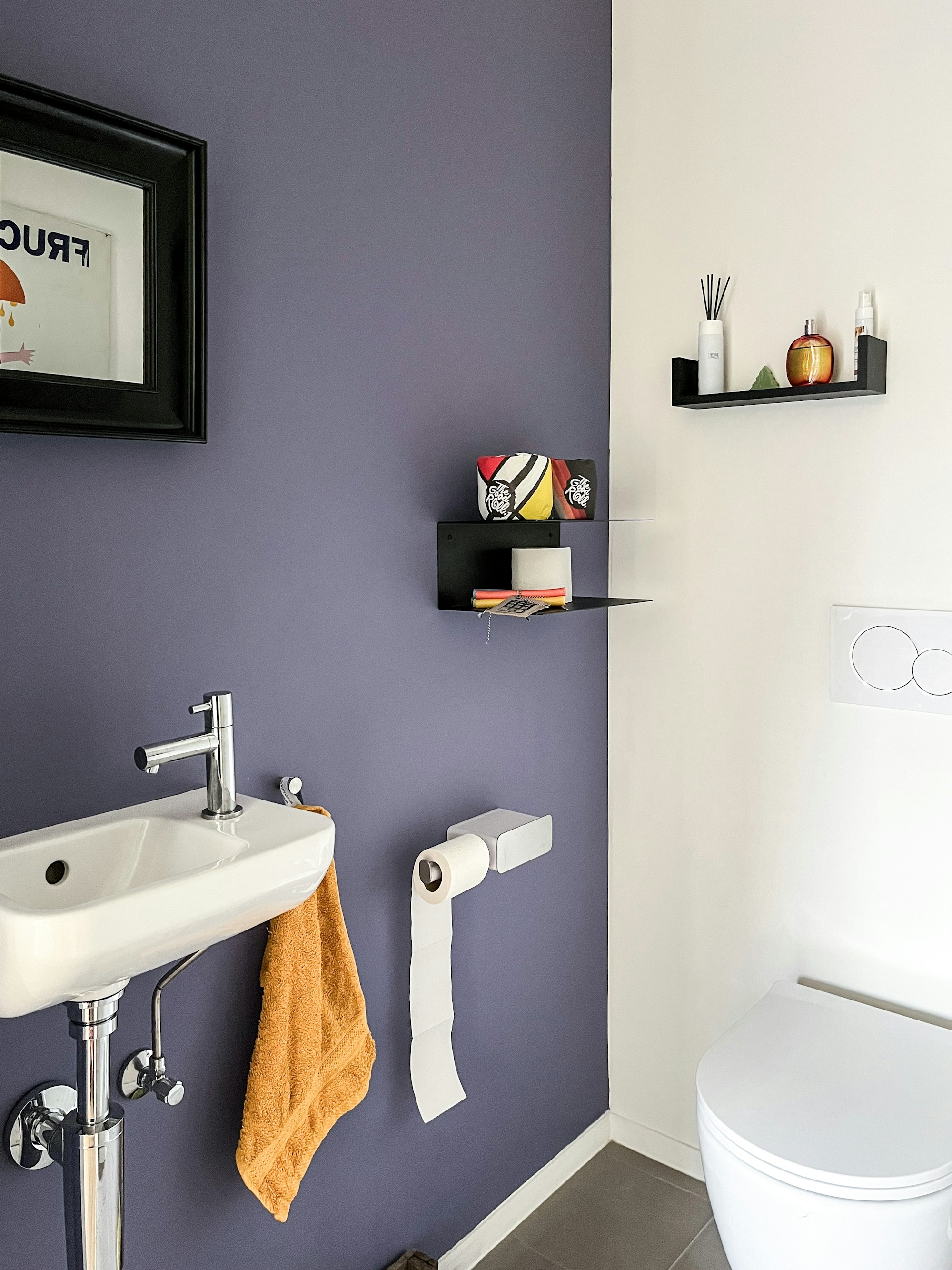 Toilet in een Skilpod prefab woning, accentmuur in paars en kleurrijke wanddecoratie
