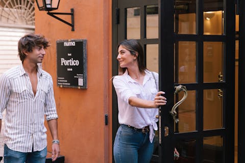 Couple entering numa Portico hotel. Italy, Rome.