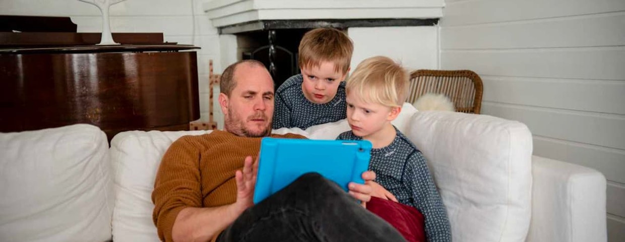 En pappa och två barn löser mattetal tillsammans