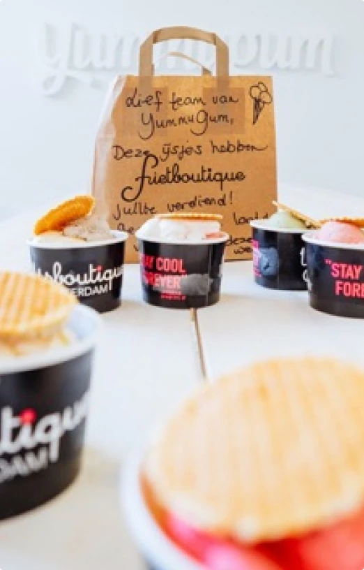 ice cream cups with wafers on a table with a brown paper bag the ice cream cups shipped in