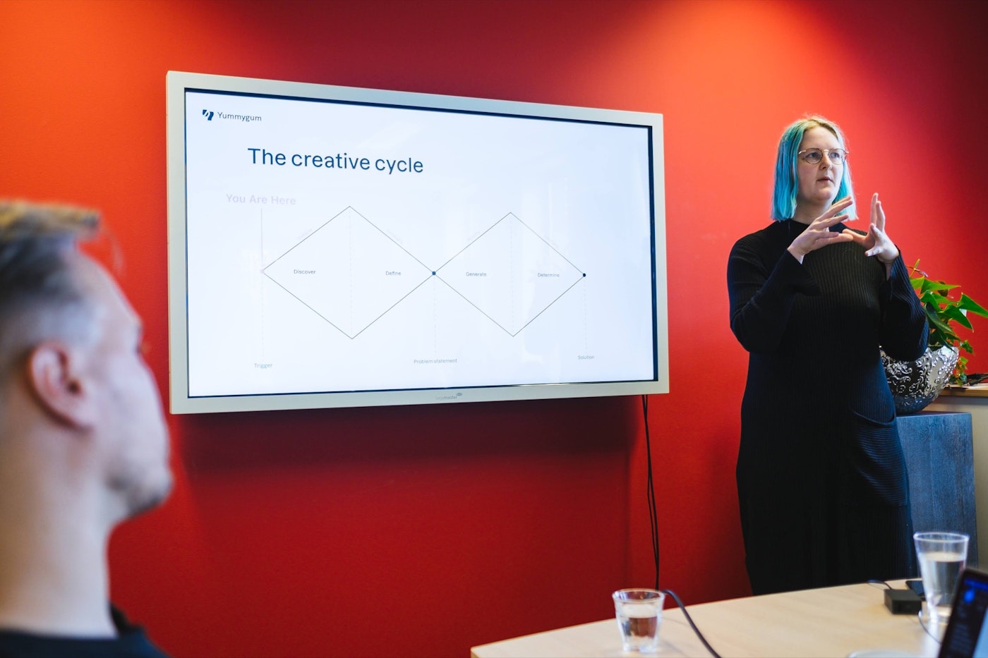 Presentation in front of a red wall and tv