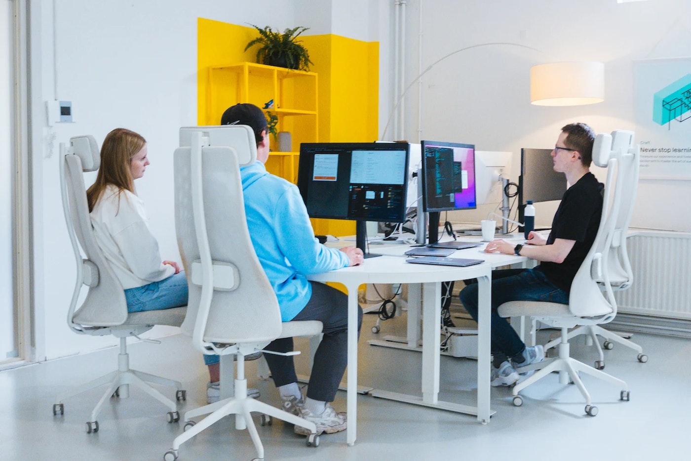 Three developers, amongst who former Front-end Development Intern Margot. Margot is watching along on her internship supervisor Donovan's screen.