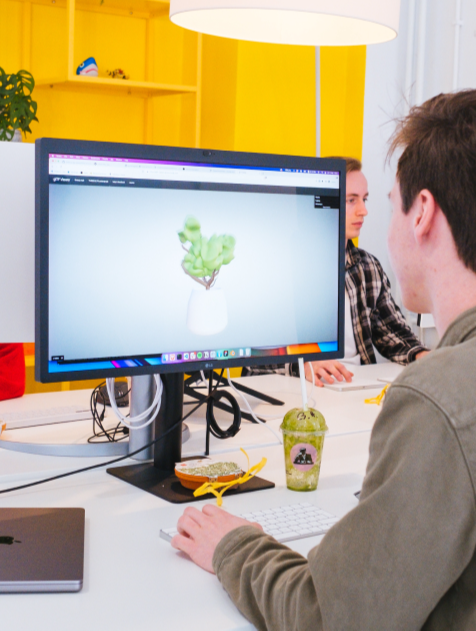 Man working on a 3D model behind computer monitor