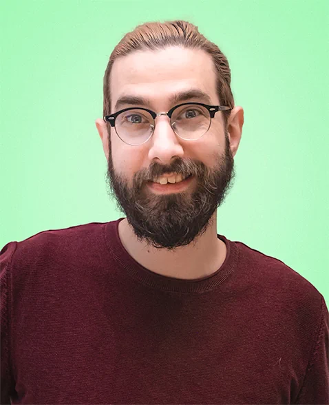 Portrait picture of Yummygum team member David  against a light green backdrop while wearing a dark red sweater.