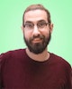 Portrait picture of Yummygum team member David  against a light green backdrop while wearing a dark red sweater.