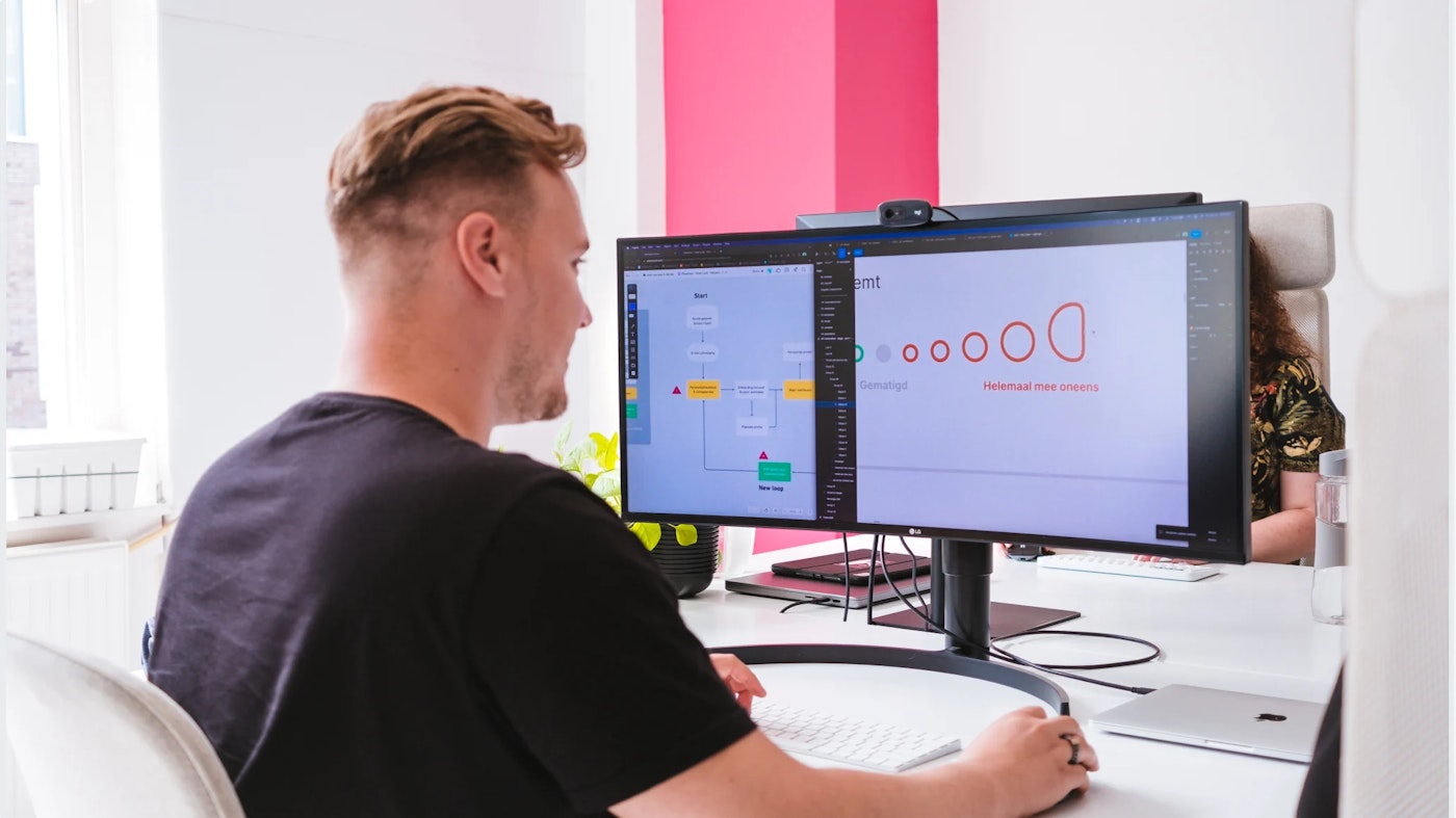 Person working on computer. The computer screen shows both a diagram and a flowchart.