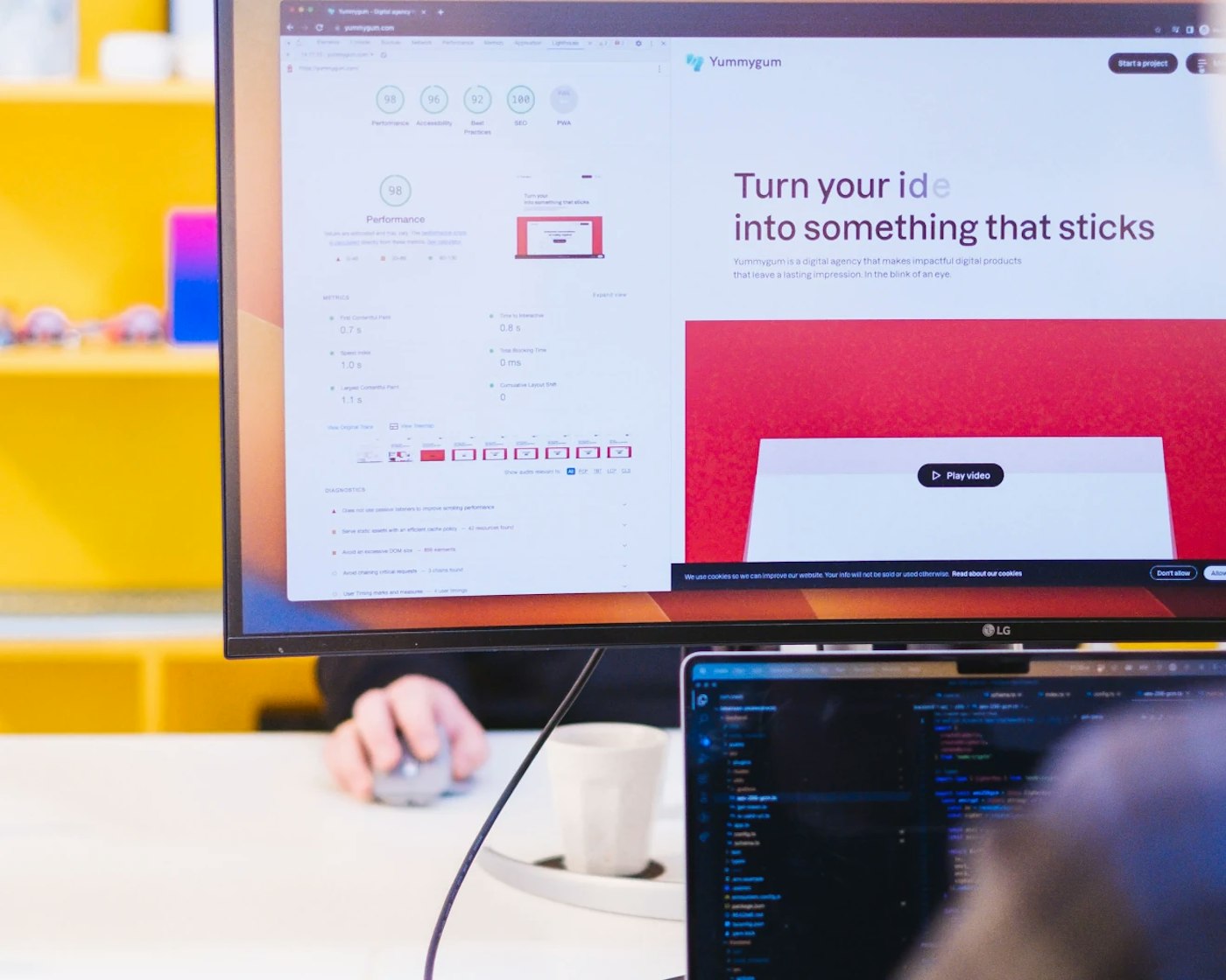 Computer monitor showing a website with on the left Lighthouse Score metrics, indicating the performance rating of the website. In the rear is a bright yellow colored wall.