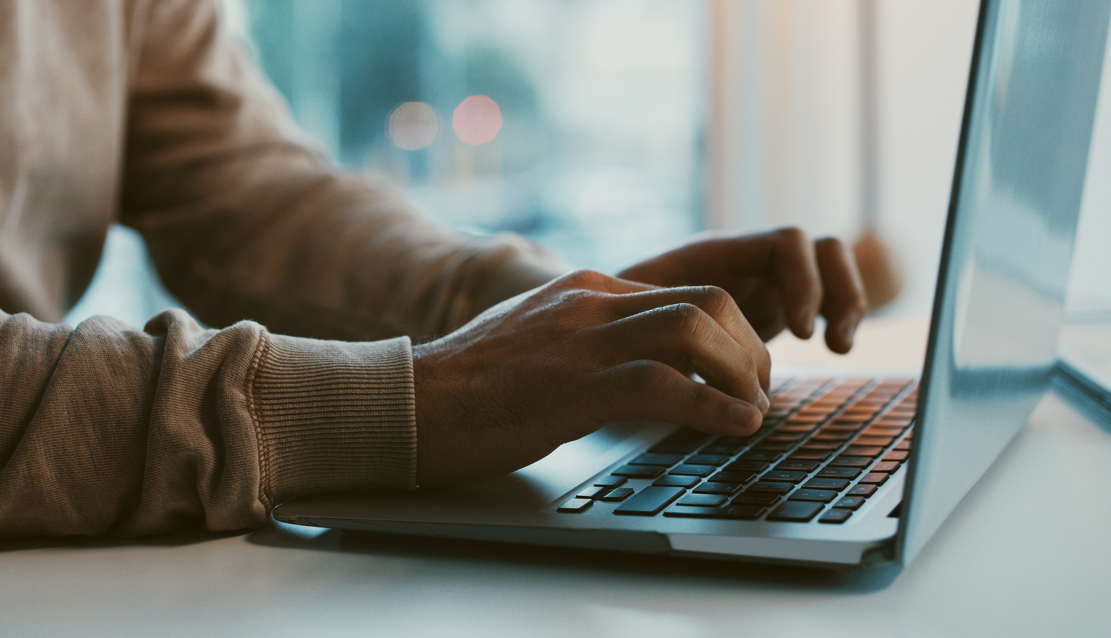 Hands typing on a computer