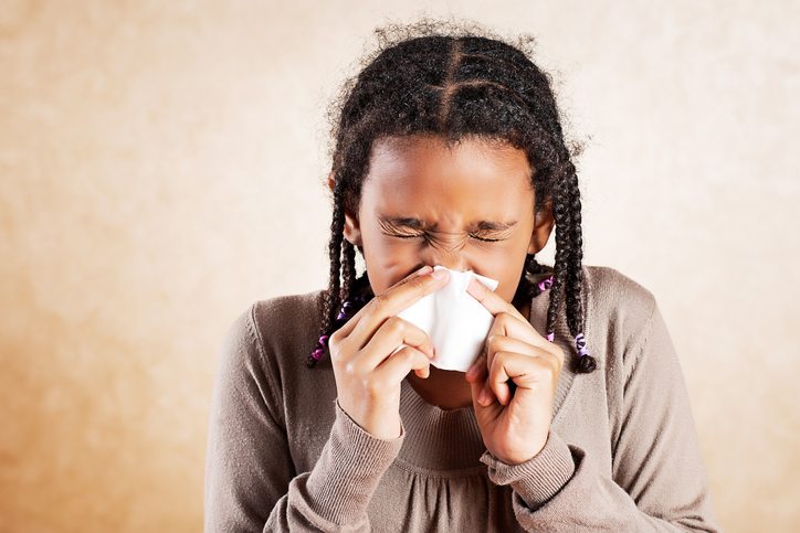 Girl blowing nose with Allergies