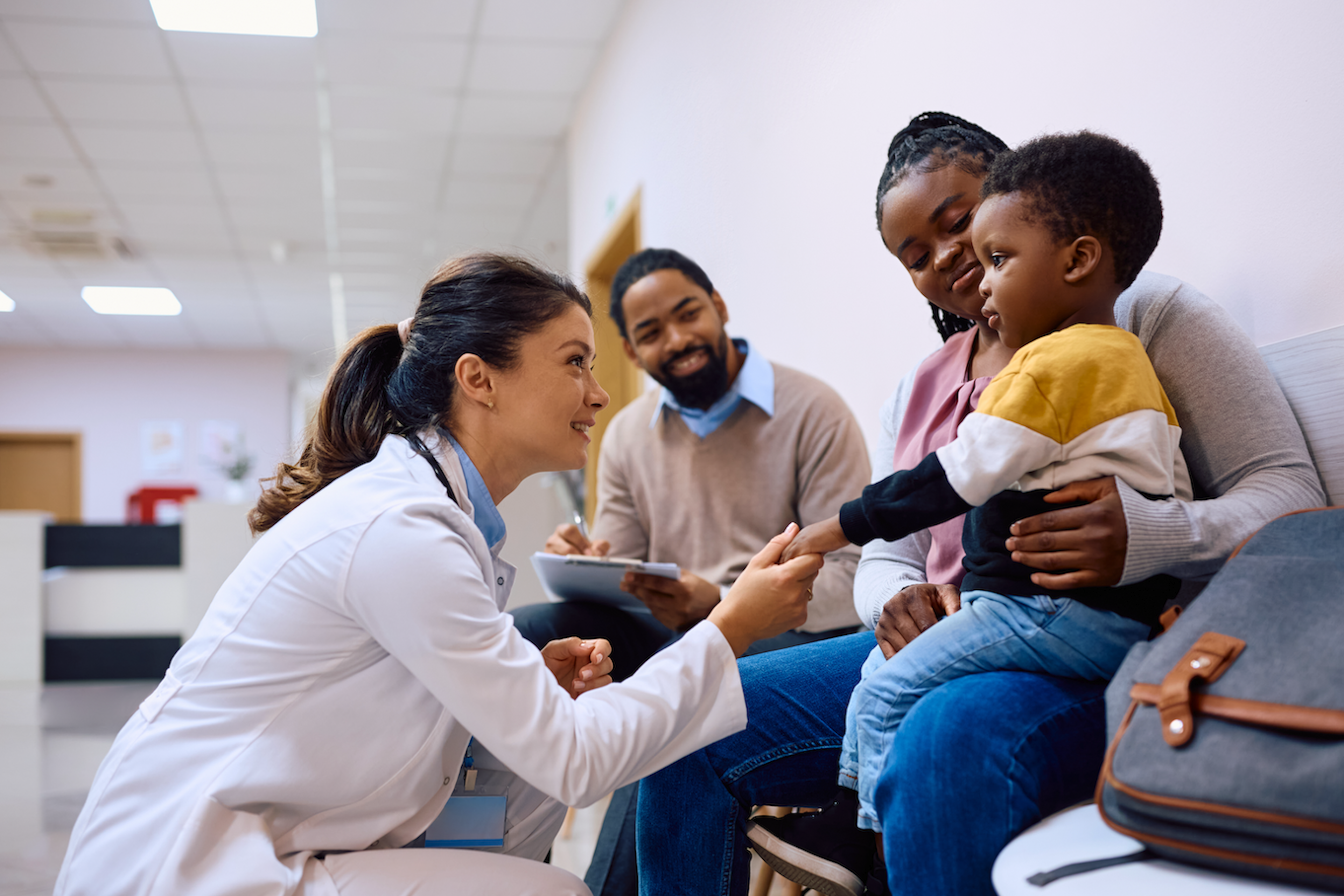 Doctor greeting family in medical office