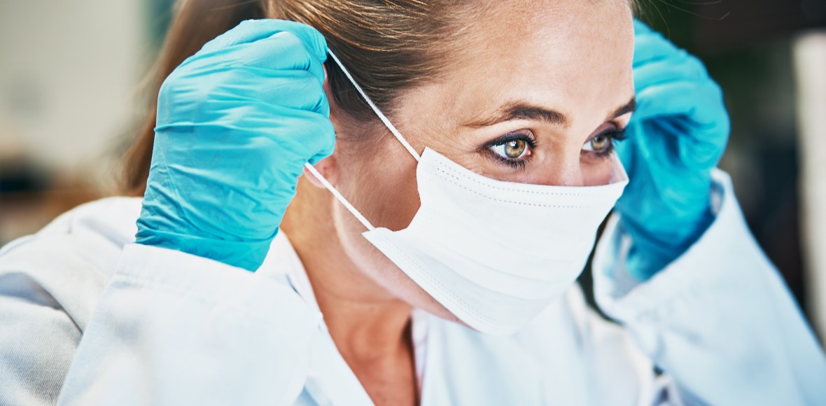 Medical professional puts on a mask.