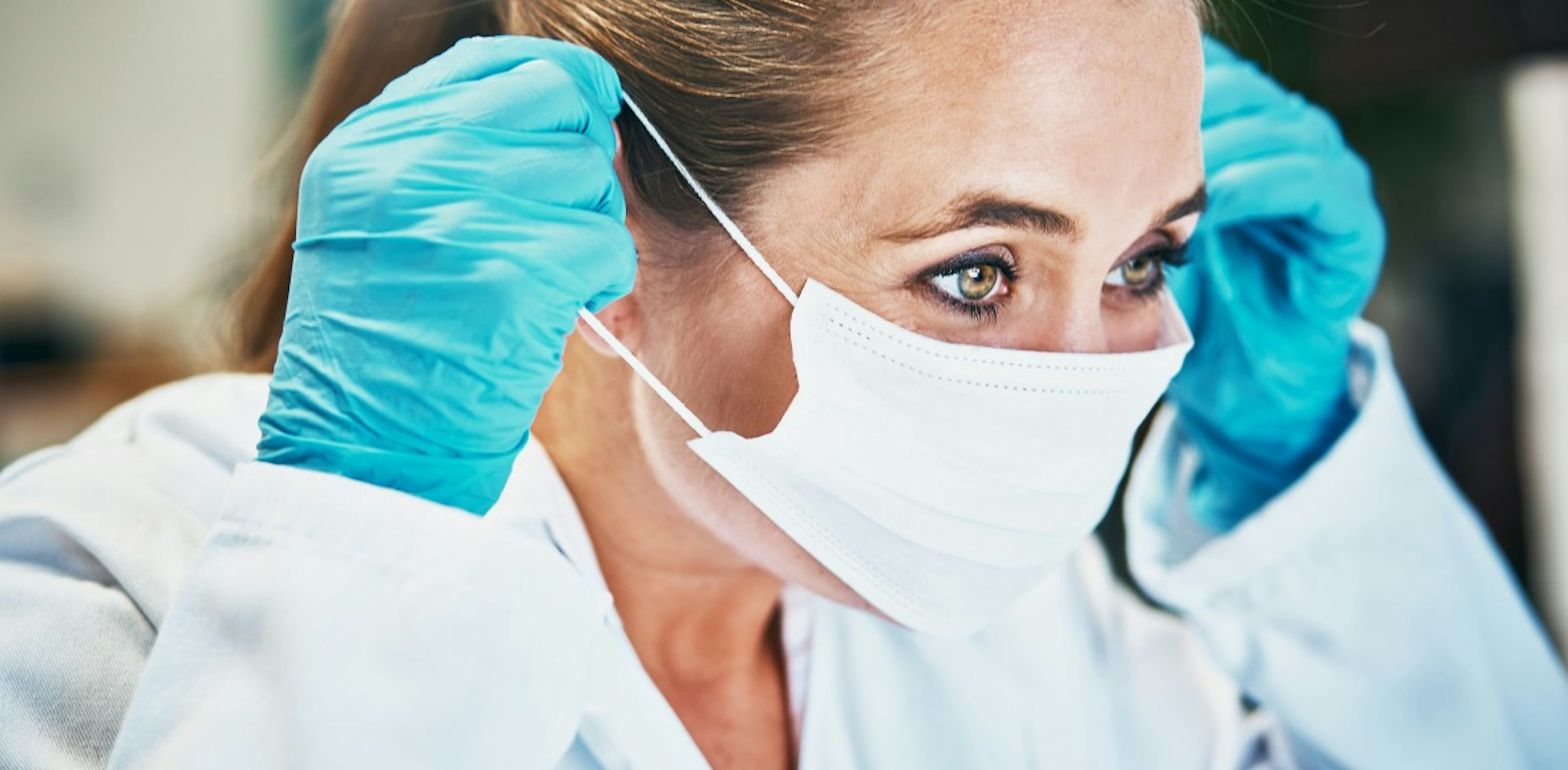 Medical professional puts on a mask.