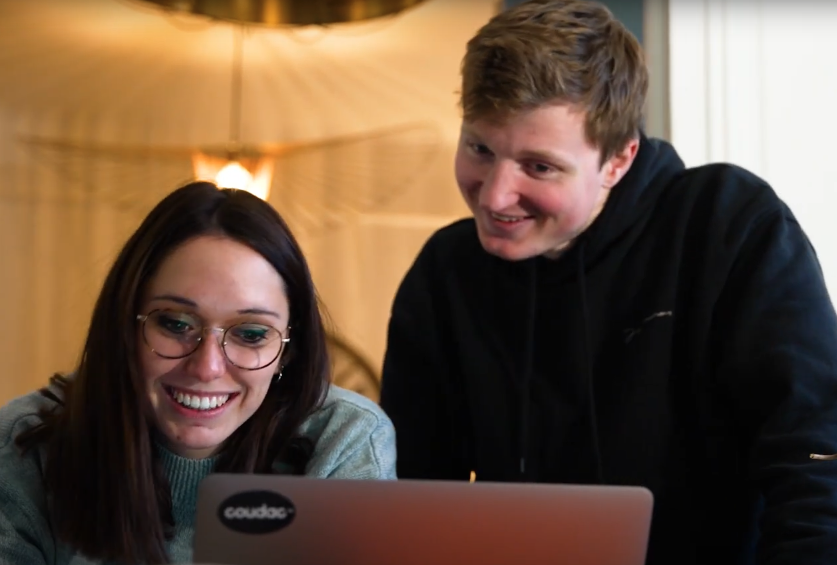 Photo de deux employés d'entreprise travaillant joyeusement sur un ordinateur.