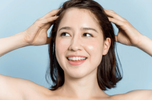 brunette model smiling with her hands in her hair