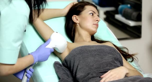 brunette patient receiving a laser hair removal session