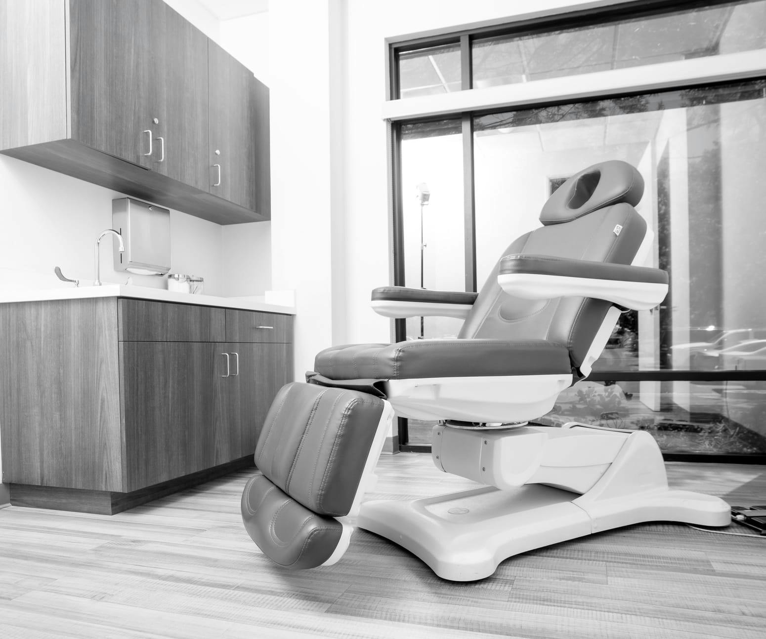 A black and white image of a procedural chair at Pure Beauty Medical Spa