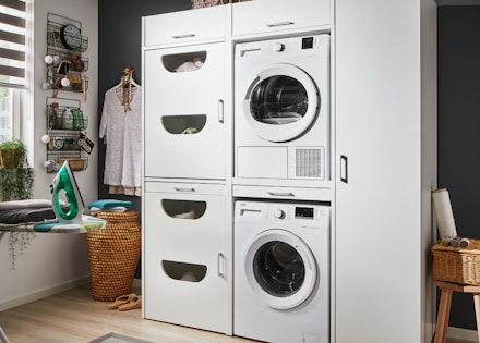 Hauswirtschaftsraum mit gestapltern Waschmaschine und Trockner