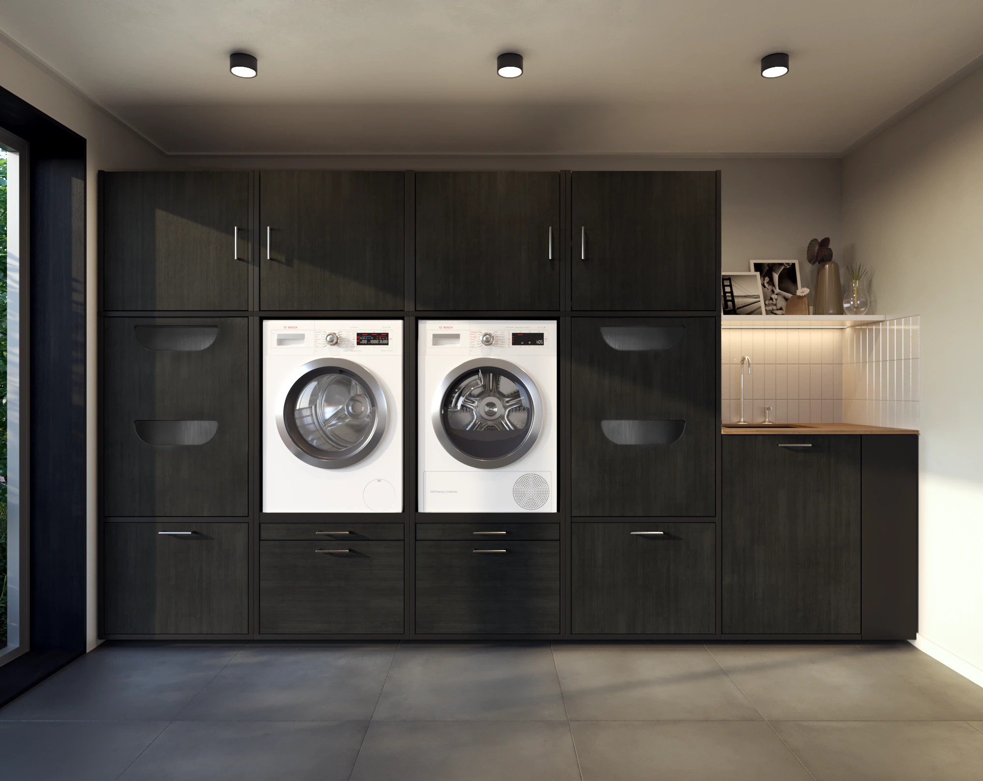 Lifestyle picture of black washing machine and dryer cupboard wall with laundry basket cabinets