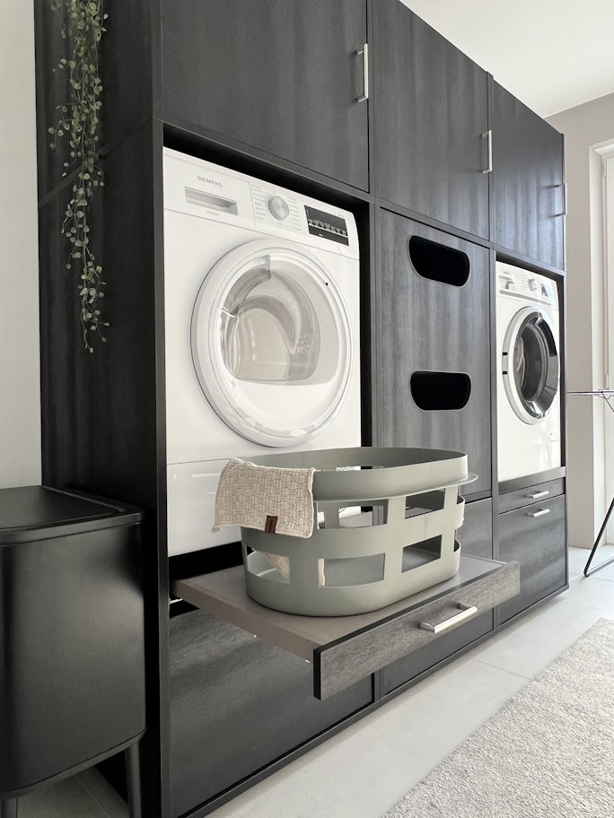 Ein schwarzer Waschmaschinenschrank als Überbau von Waschturm. Ideen und Inspirationen