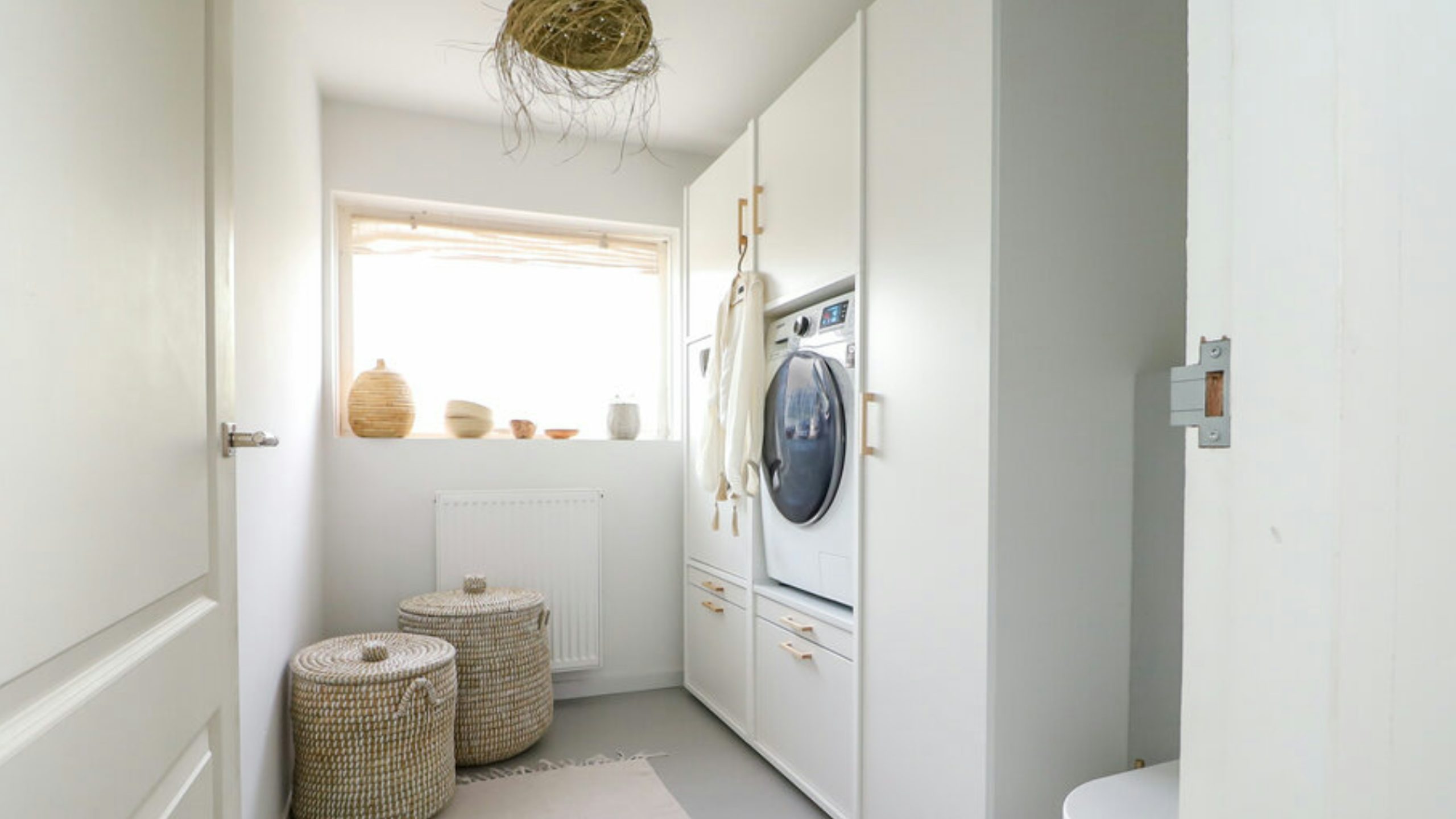 Wasmachine en droger hoger geplaatst doormiddel van stevige wasmachine kast met opbergruimte, uittrekbare plank voor de wasmand en onderkasten