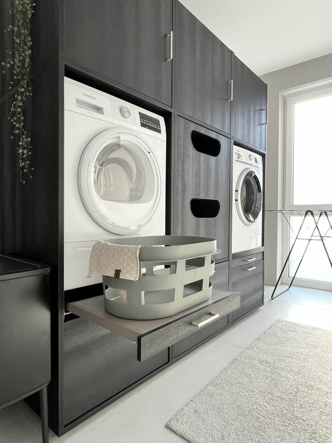 Zwarte wasmachine kast. De wasmachine verhoger zit op de ideale werkhoogte (60 cm hoog). De verhoging komt standaard met een uittrekbare lade en lekbak bij Wastoren