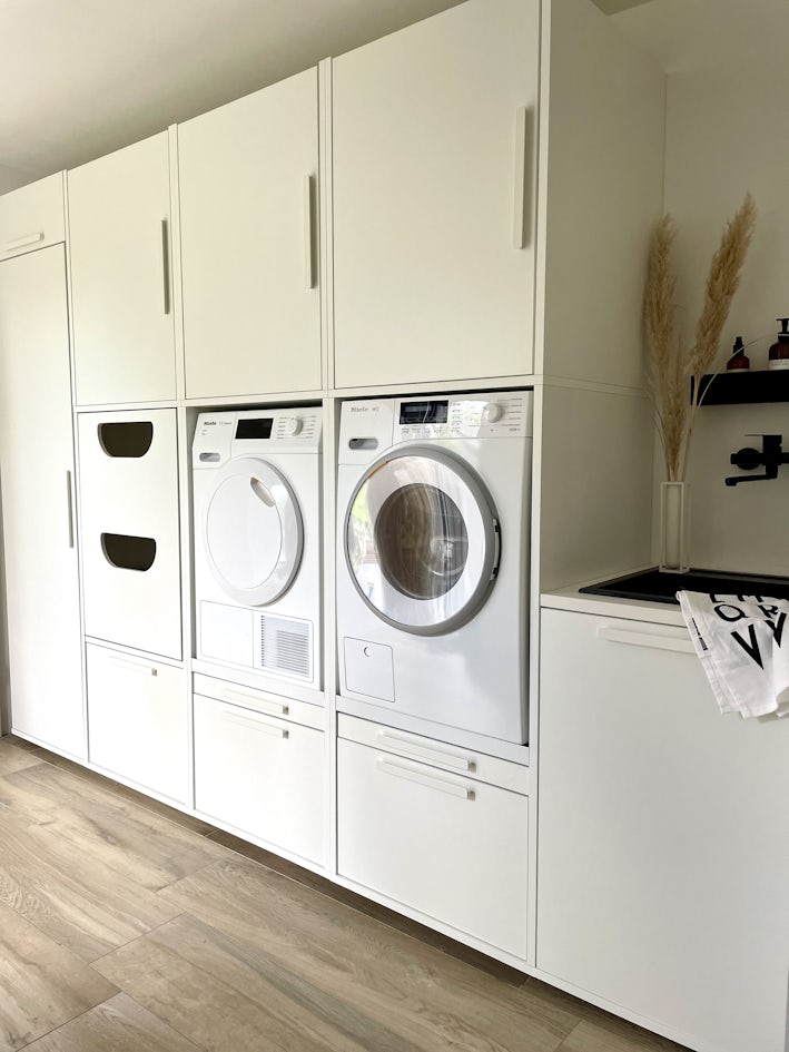 Wasmachine kast opstelling met verhoger/ verhoging voor de wasmachine en droger. De kast heeft een speciale korflade voor de wasmand, lekbak en uittreklade