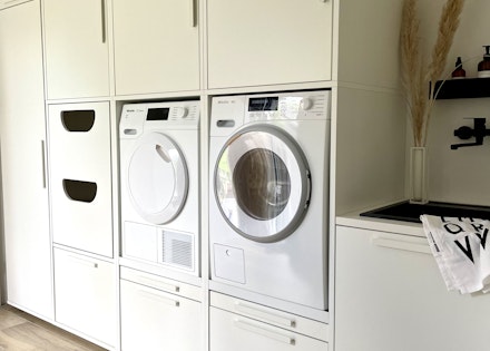 Wasmachine kast opstelling met verhoger/ verhoging voor de wasmachine en droger. De kast heeft een speciale korflade voor de wasmand, lekbak en uittreklade