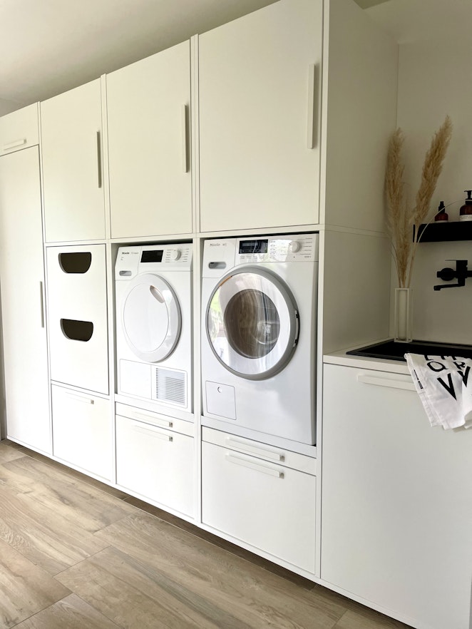Inspiration für Waschküche mit weißen Schränken von Waschturm
