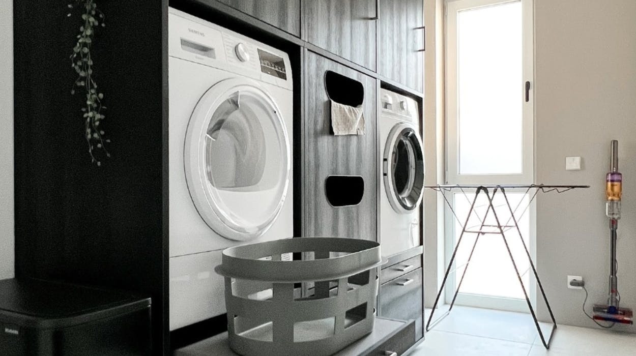 Komfort durch schwarzen Schrank mit erhöhter Waschmaschine und Ausziehplatte