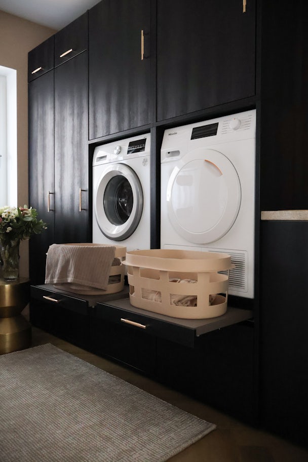 zwarte dubbele wasmachine kast met uittrekplateau voor wasmand en korflades voor wasmand met opzetstuk onderkast inspiratie en ideeen