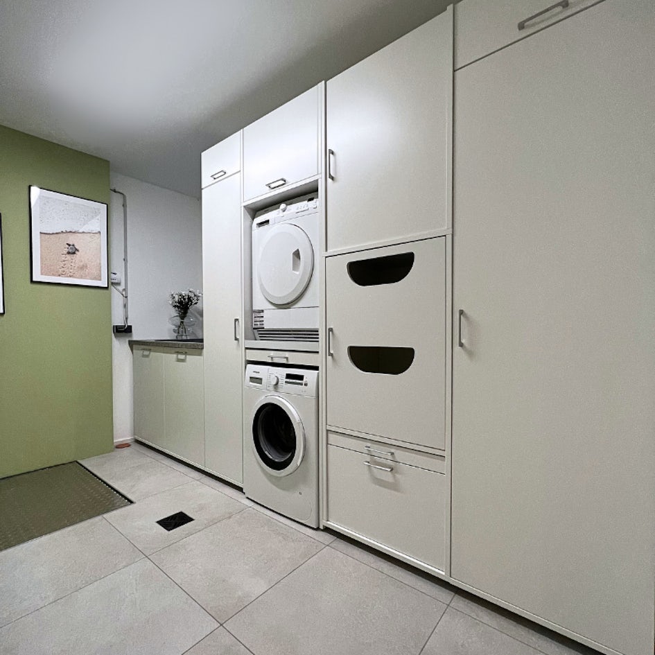Kastenwand met een wasmachine en droger combinatie. De bijkeuken beschikt ook over een inbouwkoelkast. Plaats je droger boven op de wasmachine!