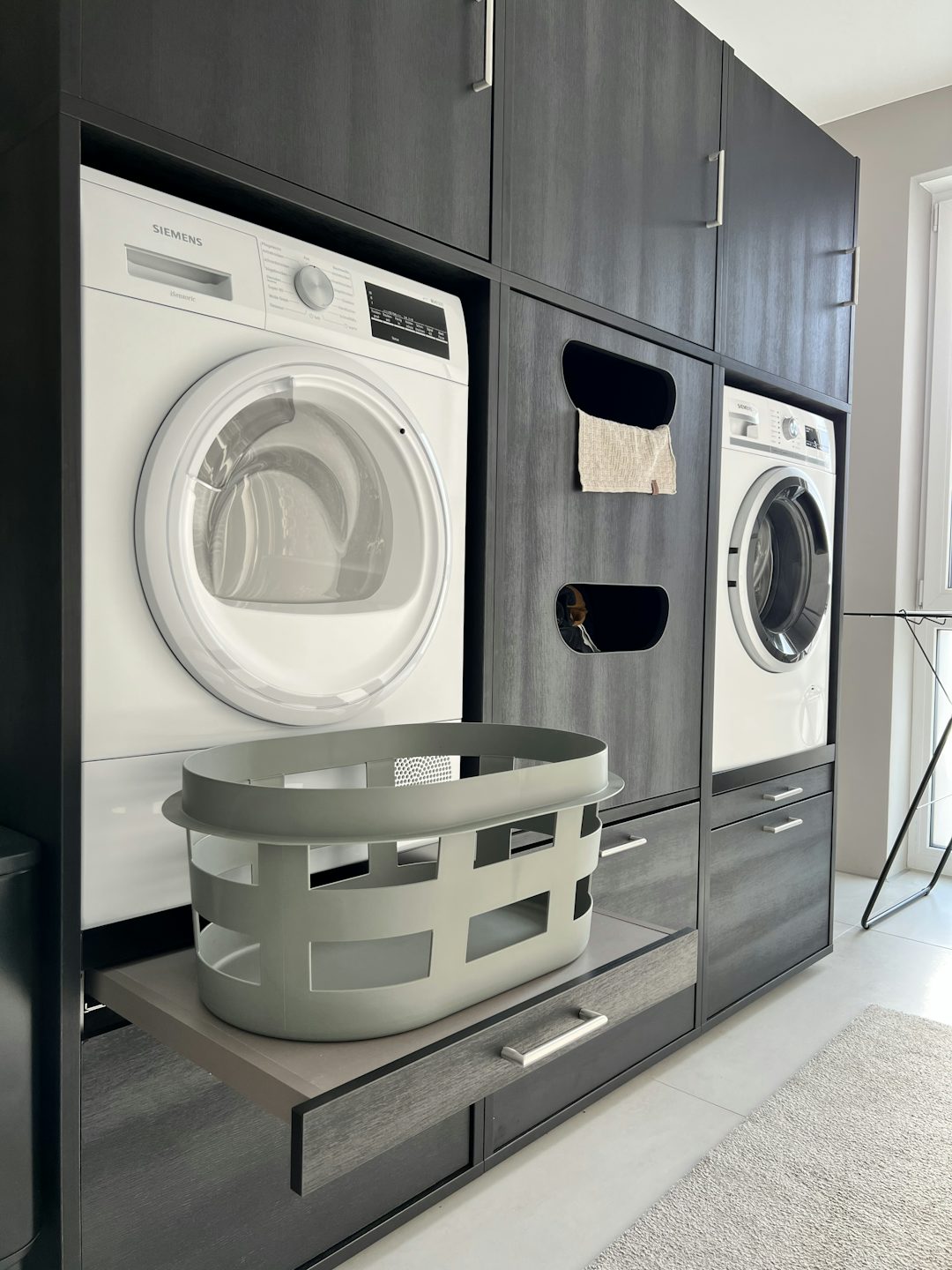 dubbele wasmachine kast droger en wasmachine naast elkaar met uittrekplateau voor wasmand en korflades voor wasmand en wasproducten en een inzetstuk voor wasmand met opbergkasten ideeen inspiratie