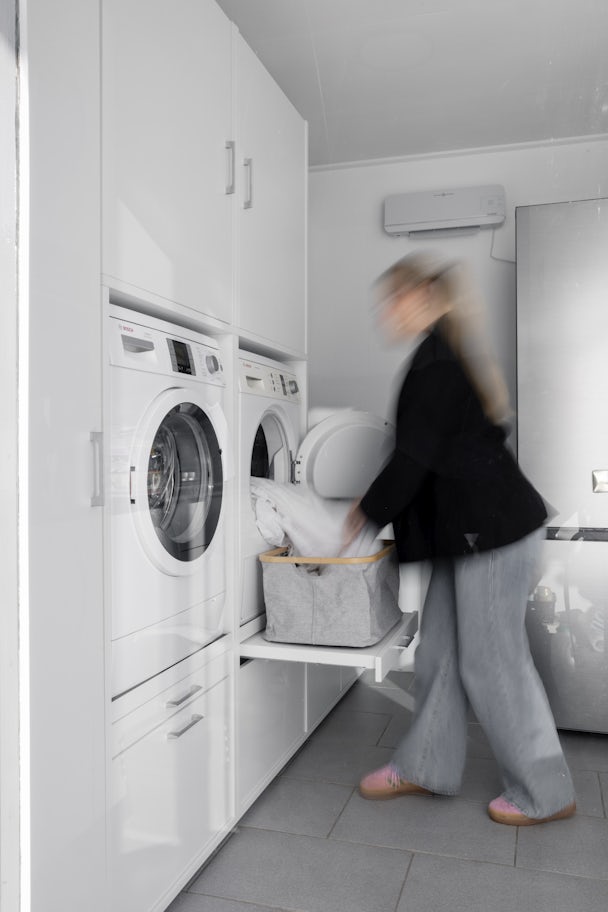 dubbele wasmachine en droogkast verhoger wit in de bijkeuken inspiratie ideeen met uittrekplateau voor wasmand verhoogd naar 60 centimeter met opbergkasten voor wasproducten
