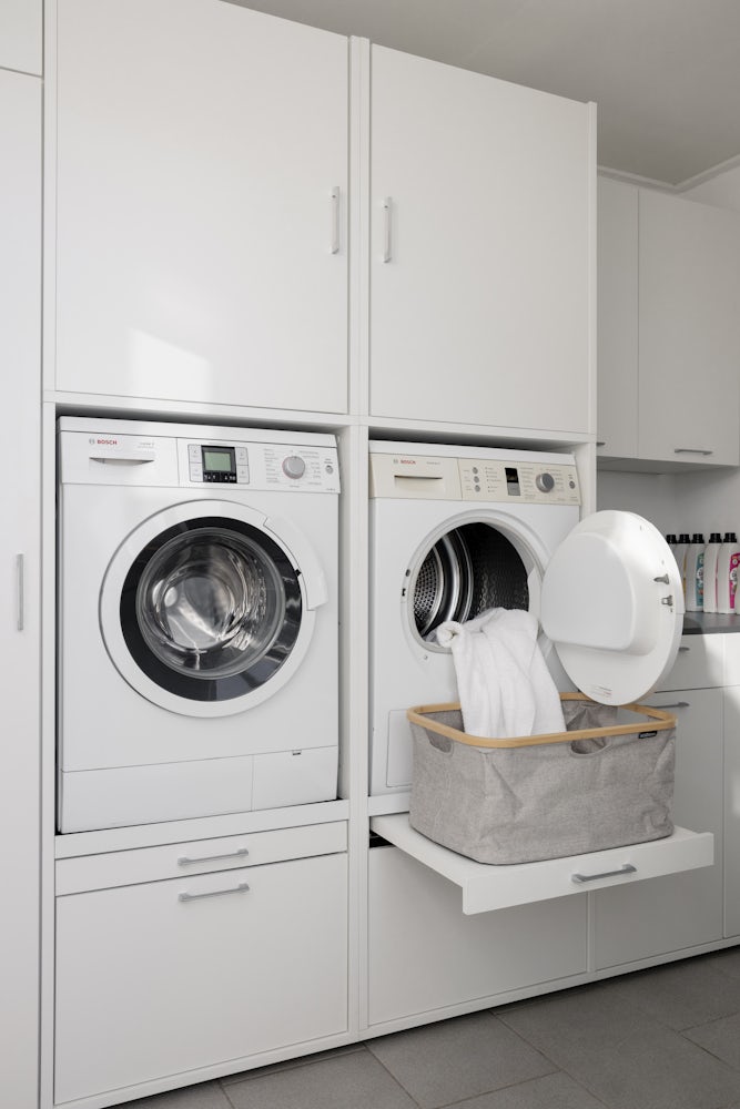 Wastoren dubbele waskast met wasmachine onderkast wit met wasmachine en droogkast naast elkaar met uittrekplateau voor wasmand en bijkeukenopstelling verhoger wit