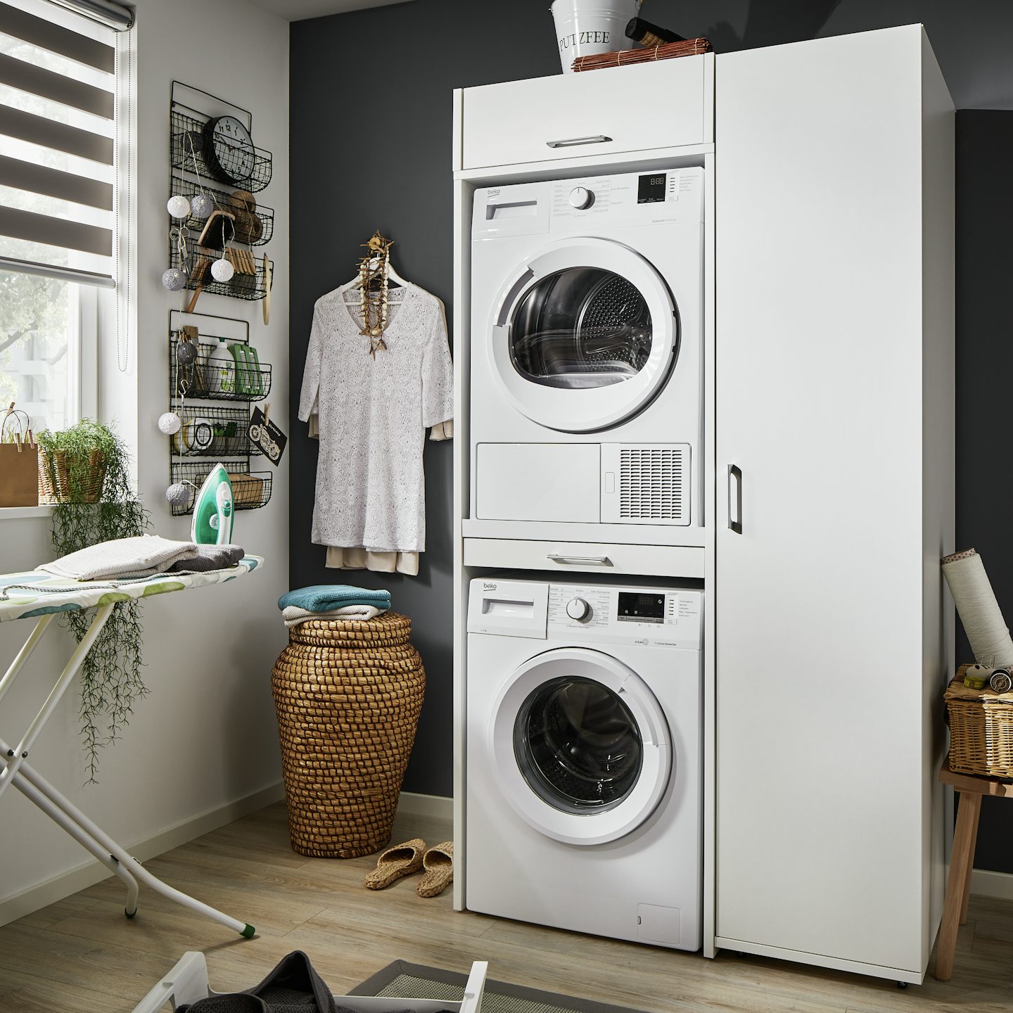 dubbele wasruimte kast in het wit met droger en wasmachine op elkaar gestapeld in de bijkeuken en wasruimte met hoge opbergkast ernaast die je op verschillende manier kan inrichten inspiratie idee