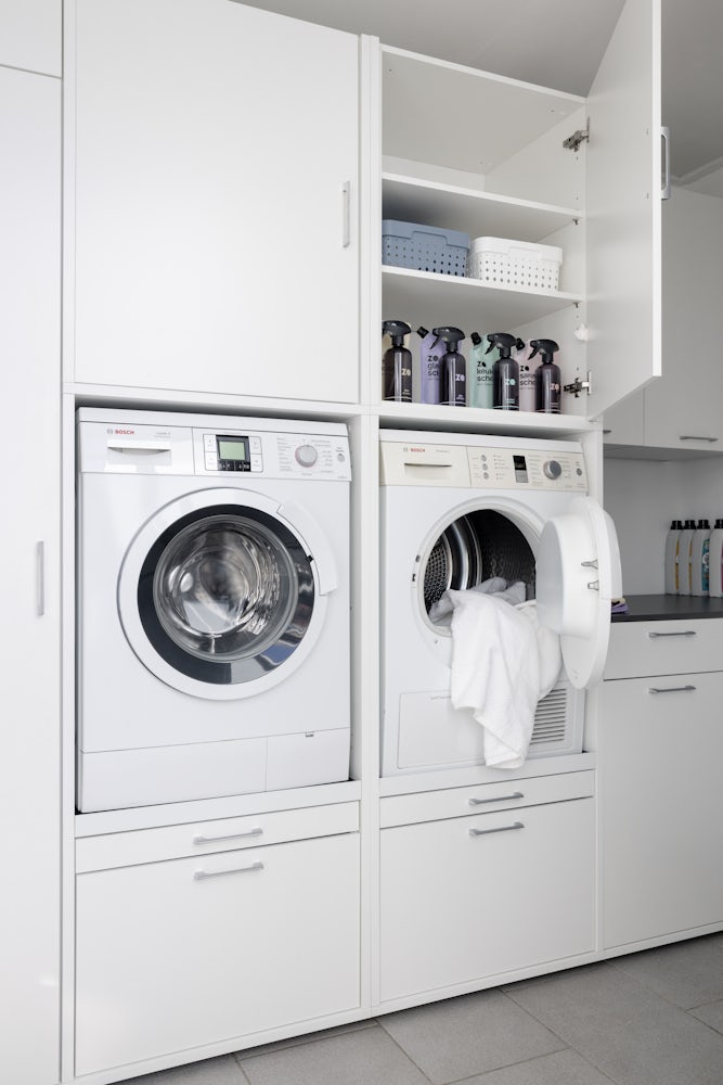 Washtower A white washing machine and dryer installed next to each other in a cabinet to showcase its benefits