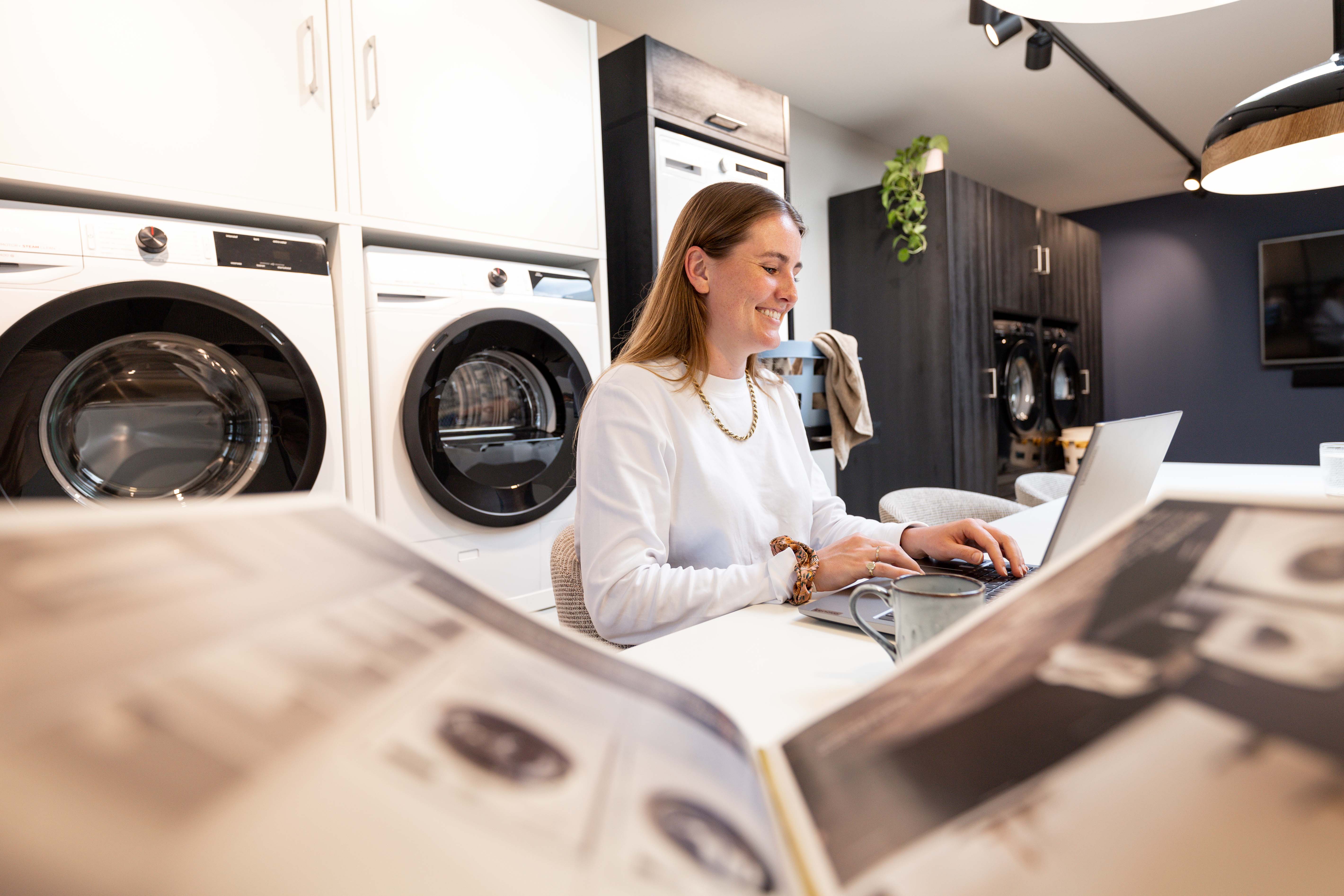 Lächelnde Mitarbeiterin vom Kundenservice von Waschturm™ hilft Kunden mit Schrankentwurf