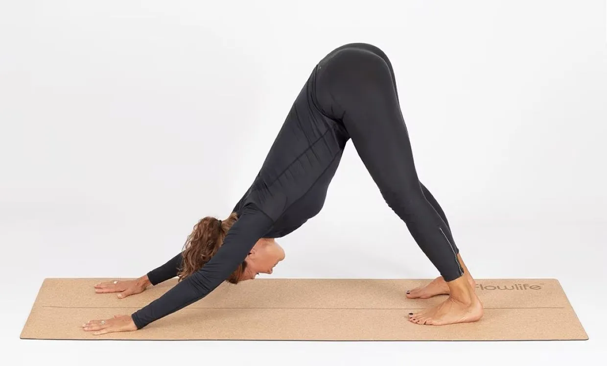 Woman standing in the dog-walking yoga position on a Flowlife yoga mat