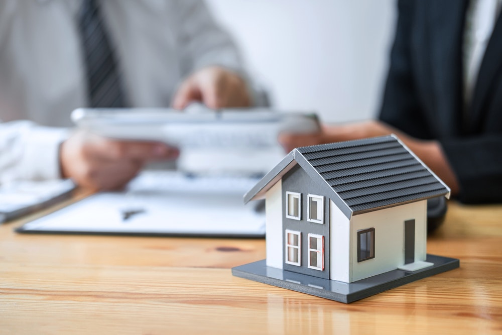 Un agente immobiliare presenta a un cliente una pratica per l'acquisto di un immobile.